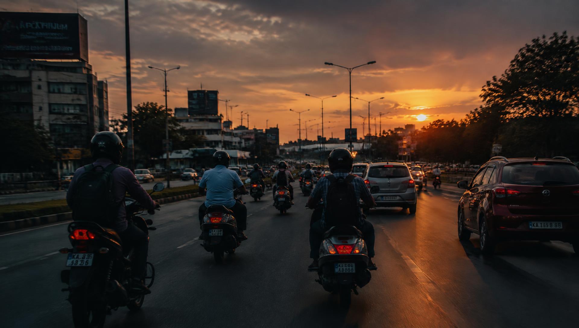 Motorcycles and scooters on an Indian road at sunset
